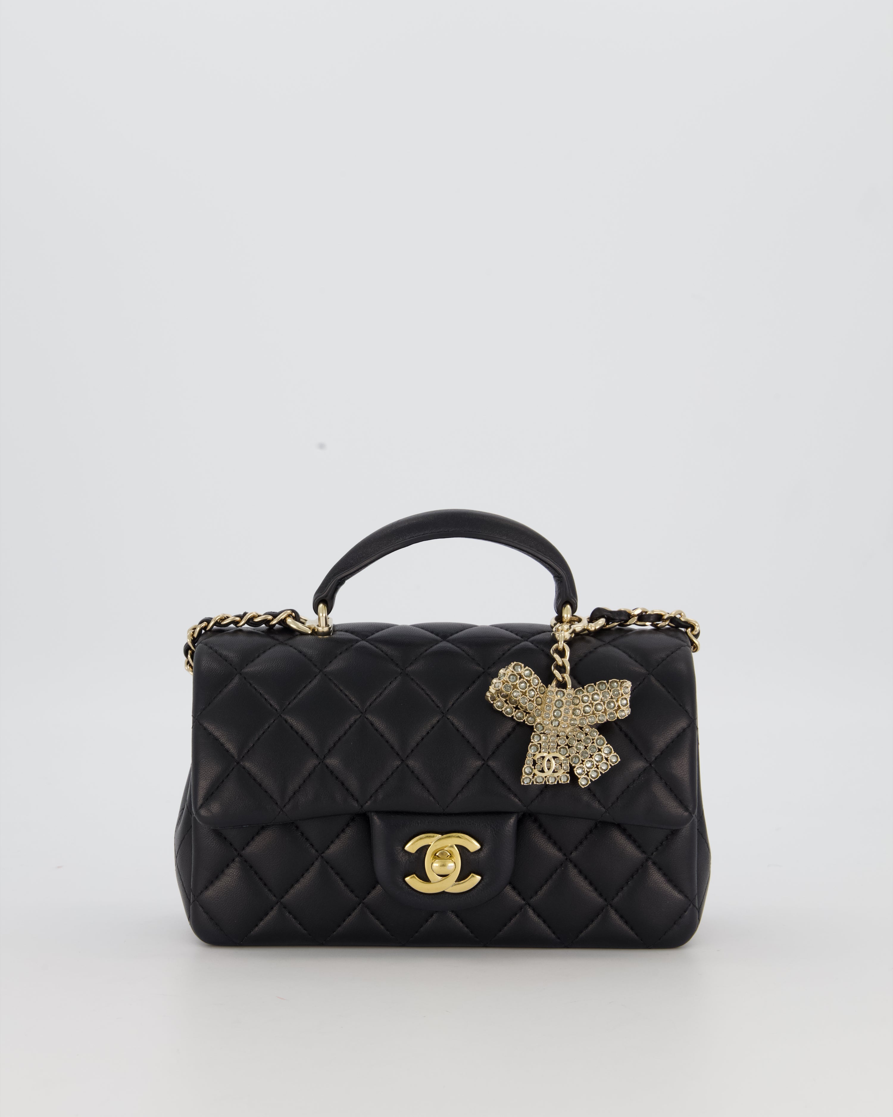 Chanel Black Mini Rectangular Top Handle Flap Bag in Lambskin Leather with Champagne Hardware and Strass Removable Bow Charm