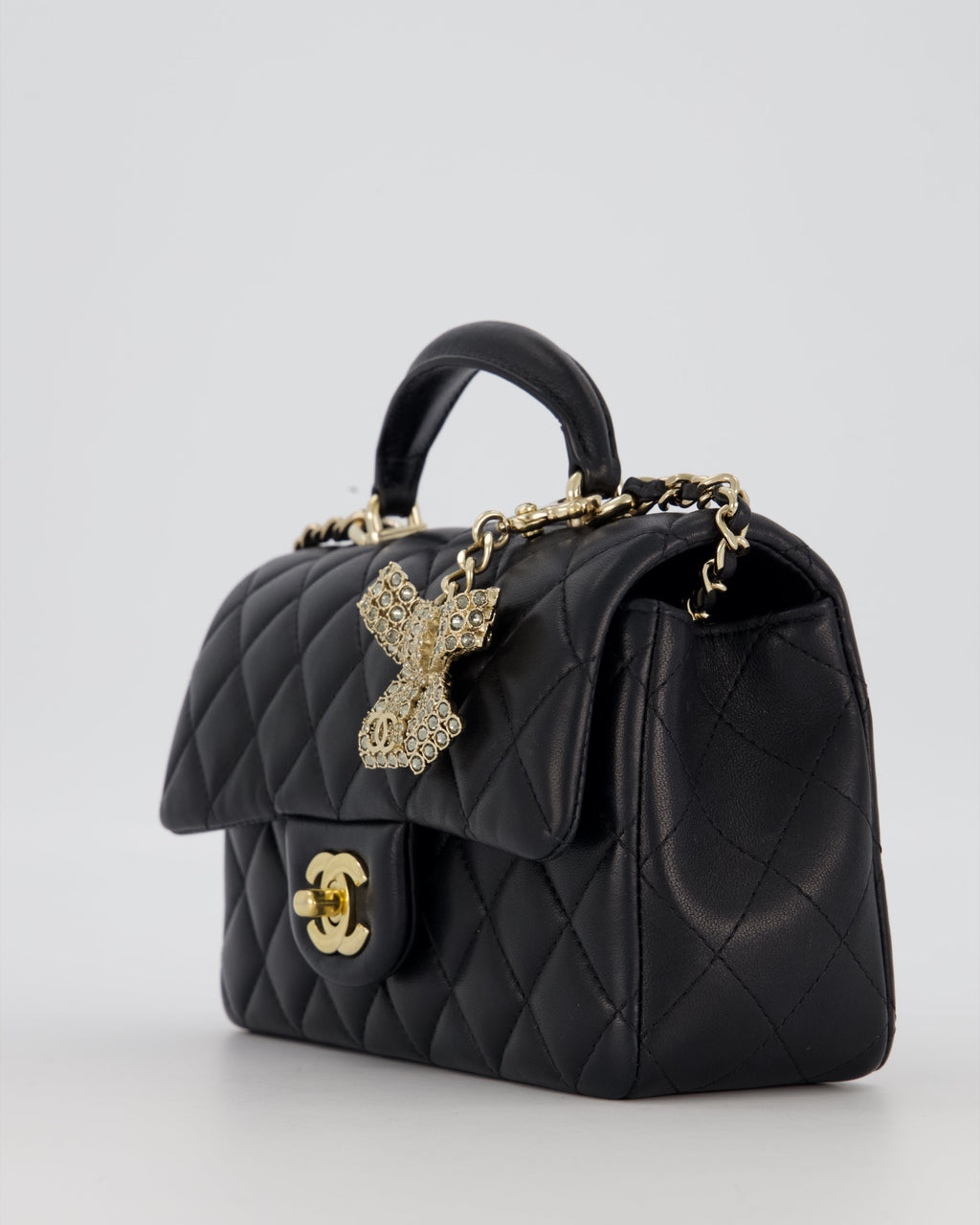 Chanel Black Mini Rectangular Top Handle Flap Bag in Lambskin Leather with Champagne Hardware and Strass Removable Bow Charm