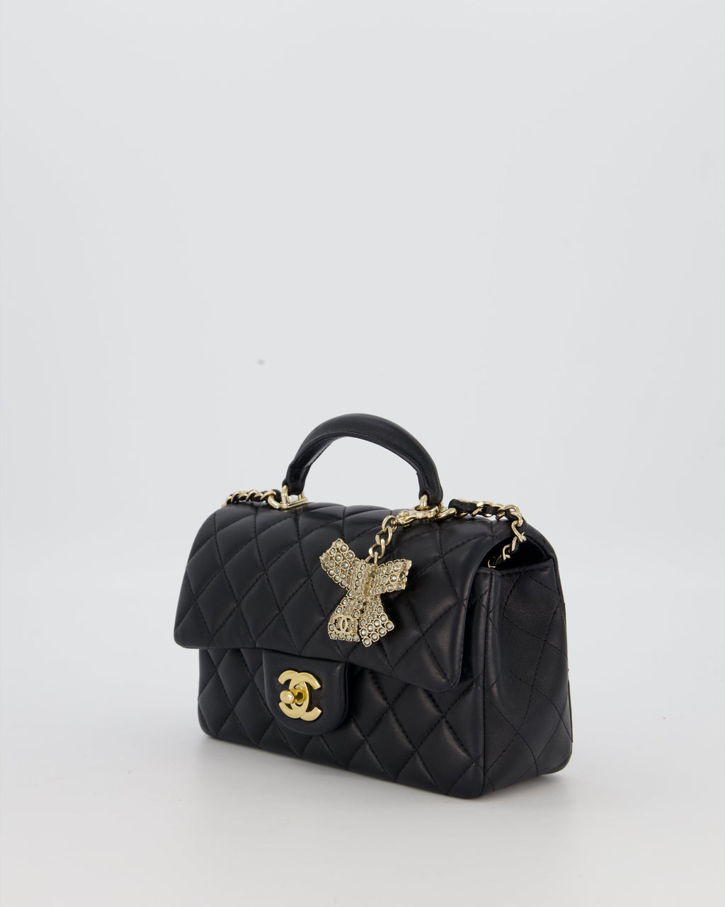 Chanel Black Mini Rectangular Top Handle Flap Bag in Lambskin Leather with Champagne Hardware and Strass Removable Bow Charm